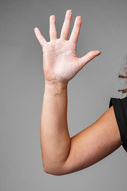 istock A raised hand demonstrating a gesture of greeting with a neutral background 2220430035