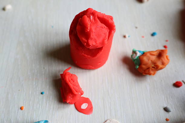 Vibrant and bright red play dough shapes adorned with colorful bits, perfect for nurturing creativity and endless fun