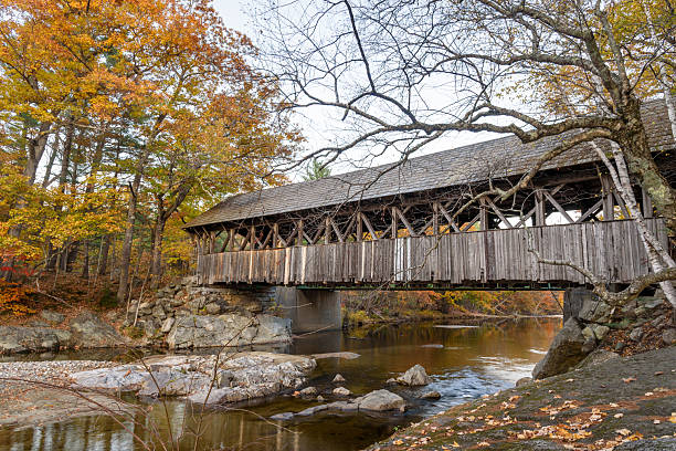 istock Historic covered bridge over a river in the mountains in autumn 2220437500
