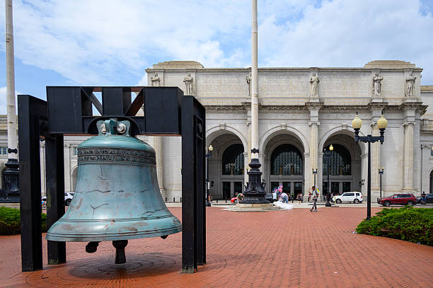 Washington DC, June 14, 2024:  Entrance to Union Station in Washington DC. The Freedom Bell, American Legion is in the foreground. The bell is a public artwork located at Union Station and is a replica of the Liberty Bell in Philadelphia. The bell, a Bicentennial gift from the American Legion, is a model of the bell on display at the American Legion Headquarters in Indianapolis, Indiana, authorized by Congress on October 12, 1976.
