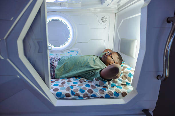 istock Person sleeping comfortably inside a modern capsule-style sleeping pod in hostel 2220442844