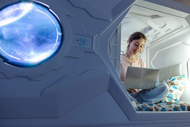 istock Woman using laptop comfortably in a modern sleeping capsule pod 2220442969