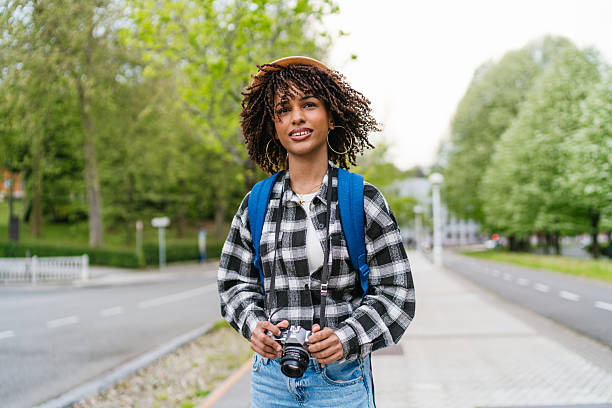 istock Young photographer walking in a park holding a camera 2220443701