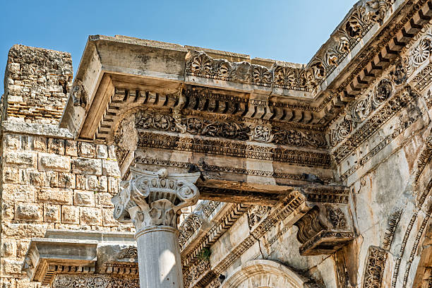 A high-resolution close-up capturing the ornate entablature and fluted Corinthian columns of the ancient Roman gateway, emphasizing the artistry of Roman stonework.