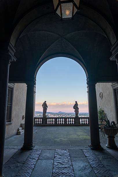 istock Arched corridor with statues overlooking cityscape at sunset. 2220446060