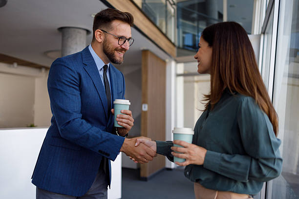 istock Professional colleagues shaking hands over coffee, representing workplace teamwork and successful business connection 2220447857