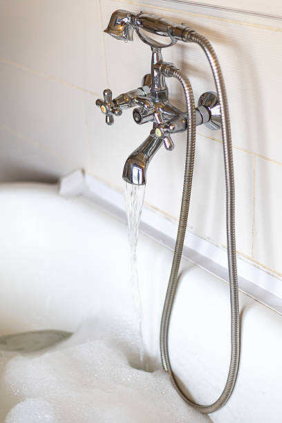 istock faucet from which a bath of water with foam is drawn, water saving, spa 2220450040