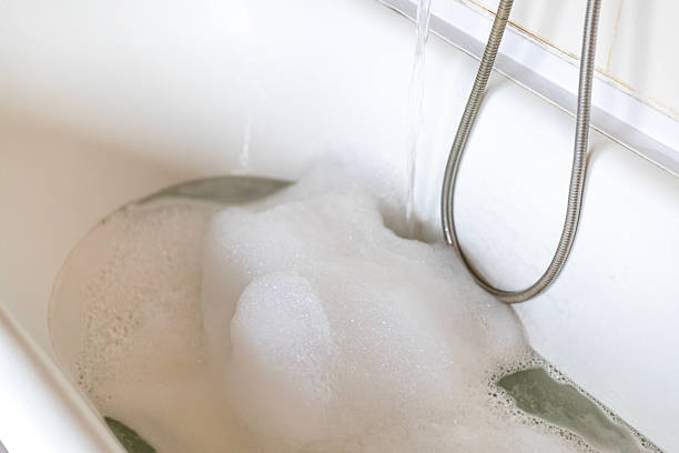istock taking water with foam into the bath, spa, relaxation 2220450042