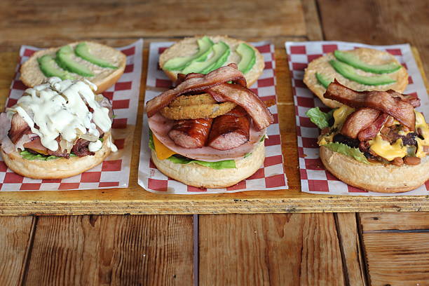 istock This image features three gourmet burgers piled high with varied toppings showcasing the culinary creativity involved in modern burger-making for food enthusiasts. 2220452612