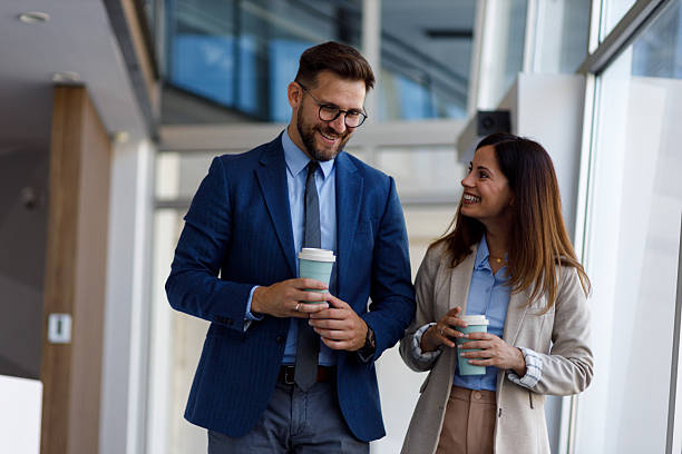 istock Business colleagues discussing project details while walking through bright office space, demonstrating professional communication and teamwork 2220453142