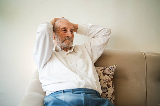 istock Lonely Elderly Man Sitting Thoughtfully at Home with Walking Cane 2220454144