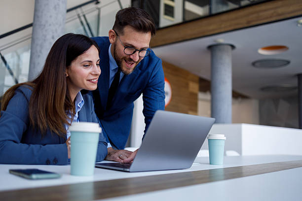istock Professional colleagues collaborating, typing on laptop near contemporary workspace windows 2220454297