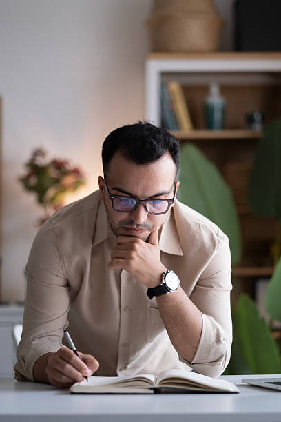 istock Businessman hand is writing on a notepad with a pen 2220454807