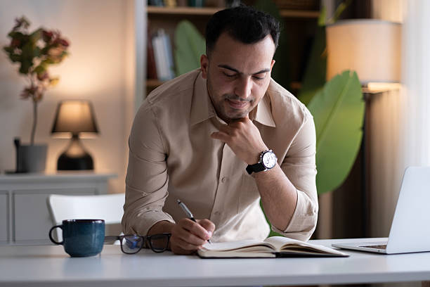 istock Businessman hand is writing on a notepad with a pen 2220454873