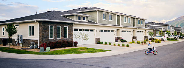 A panoramic view of a residential neighborhood with a child riding a bicycle.