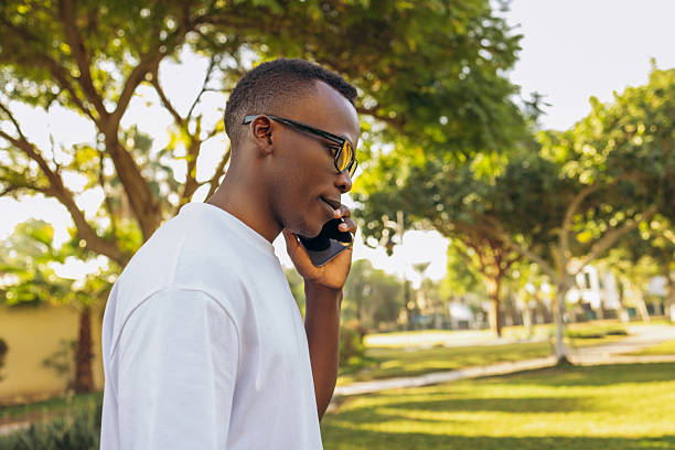 istock Man talking on smartphone outdoors in a sunny park 2220457448
