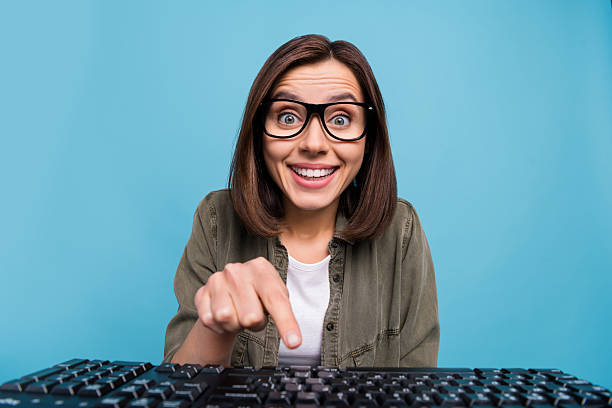 istock Photo of amazed computer nerd lady watch webcamera touch button keyboard isolated over blue color background 2220460990