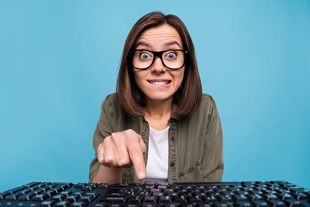 istock Portrait of anxious computer nerd lady press keyboard button look webcam social media isolated over blue color background 2220460999