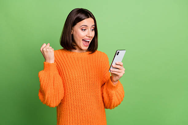istock Portrait of attractive trendy cheerful girl using device rejoicing feedback post copy space isolated over bright green color background 2220461329