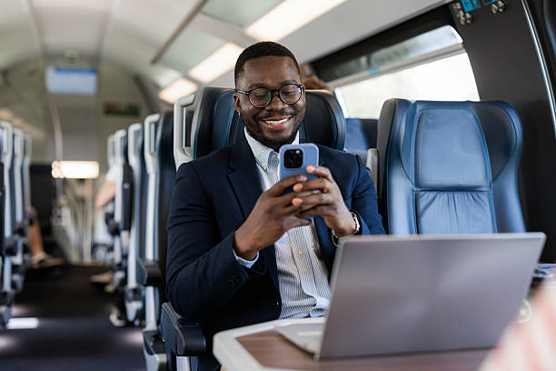 istock Businessman using smartphone and working on laptop while traveling on a train 2220462923