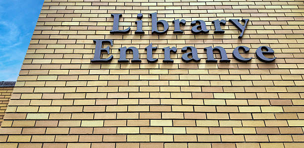 Library Entrance Sign on building brick wall with copy space.