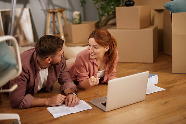 istock Couple lying on floor planning new home using laptop 2220465189