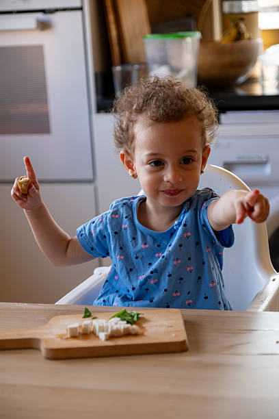 istock Young Child Enjoying a Healthy Snack in a Kitchen Setting 2220466549