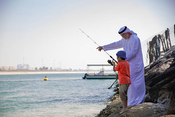 istock Arab grandfather and little boy having fun at beach 2220467739
