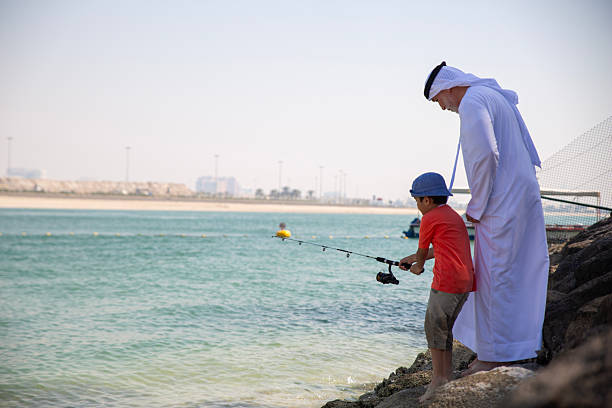 istock Arab grandfather and little boy having fun at beach 2220467741