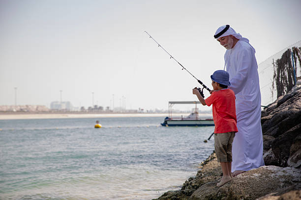 istock Arab grandfather and little boy having fun at beach 2220467757