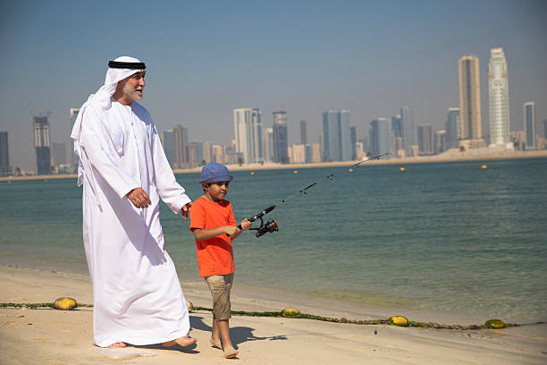 istock Arab grandfather and little boy having fun at beach 2220467914