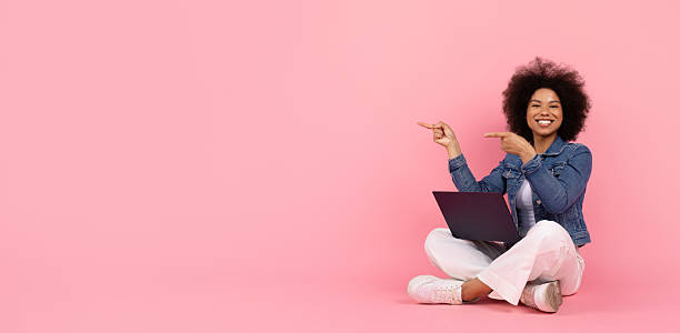 istock Nice Promo. Happy Black Woman With Laptop On Lap Pointing At Copy Space 2220468149