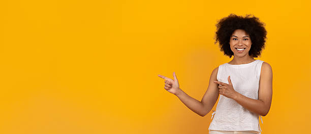 istock Smiling African American Female Pointing Aside At Copy Space With Two Hands 2220469047