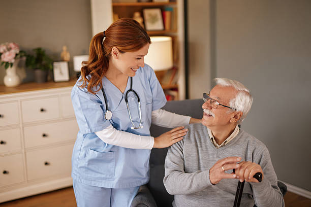 istock Nurse supporting elderly man with walking cane at home 2220470883