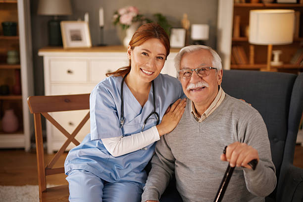 istock Nurse smiling and assisting elderly man with walking cane at home 2220470963
