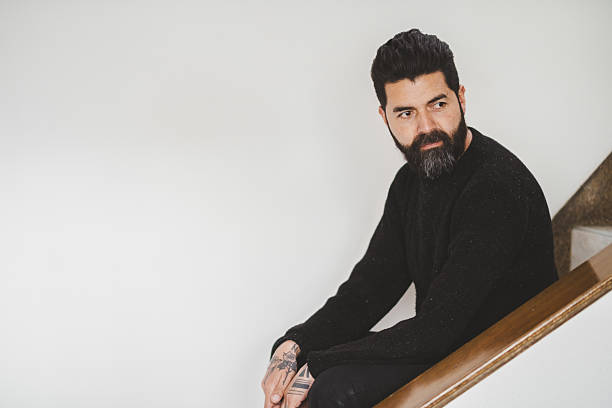 portrait of a man with tattooed hands at home