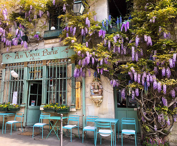 Paris, France - April 14, 2025: A sunny wisteria-covered restaurant (Au Vieux Paris d’Arcole) located behind Notre Dame Cathedral on Ile de la Cite.