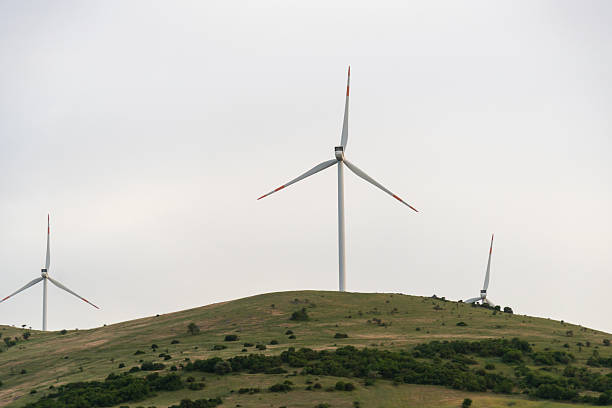 Wind turbines generating electricity, landscape with hills