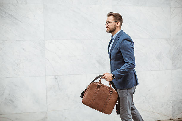 istock Businessman walking briskly with briefcase in hand 2220476761