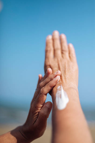istock Woman Applying Sunscreen at the Beach 2220477810