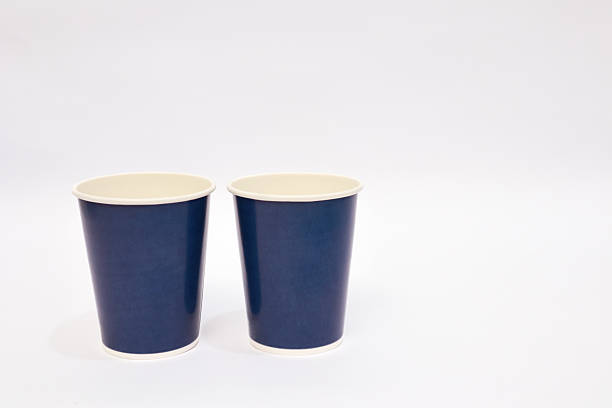 istock Two navy blue paper cups stand side-by-side on a plain white background, minimalistic and clean design 2220480290
