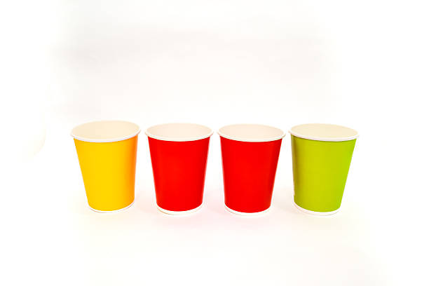 istock Four colorful paper cups standing in a row on a plain white background display. Isolated 2220480513