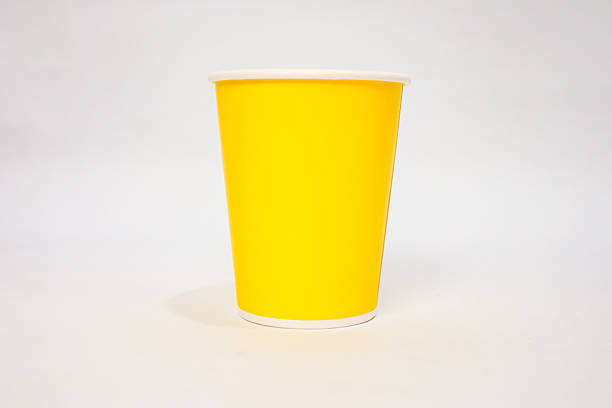 istock Vibrant Yellow Paper Cup on White Background, a simple and eye-catching visual element for diverse design projects 2220480550