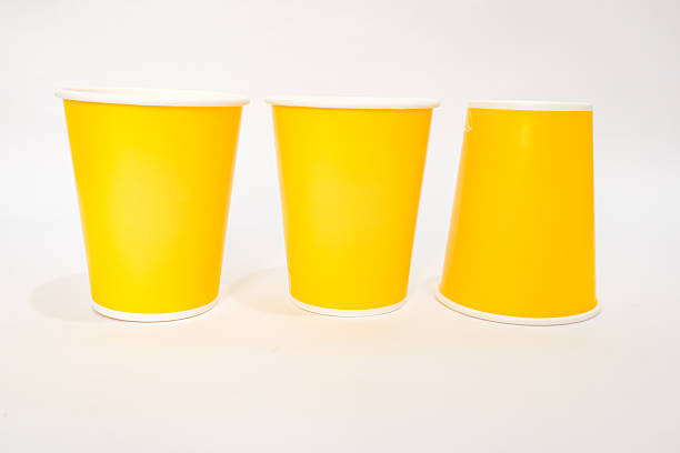 istock Three vibrant yellow paper cups arranged on a clean white background, offering a clean and bright minimalist composition 2220480551