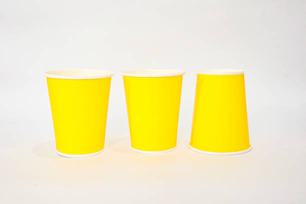 Bright yellow paper cups arranged on a white surface, perfect for events