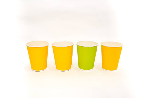 istock Bright disposable cups stand in a row, one green among yellow, ready to serve drinks 2220481242