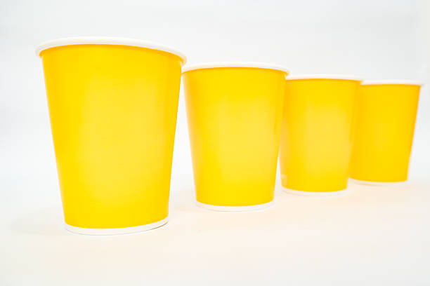 Four yellow paper cups arranged in a row on a clean white background provide a simple and clean aesthetic