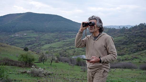 istock Mature Man Birdwatching In Spring Nature. Middle Aged Pastimes 2220483104