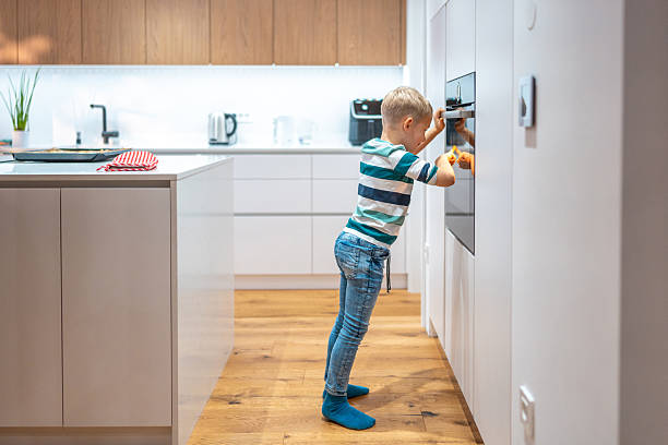 istock Curious Caucasian Boy Observing Cookies Baking 2220484992