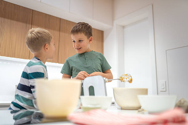 istock Caucasian Brothers Joyfully Baking Cookies Together 2220485024